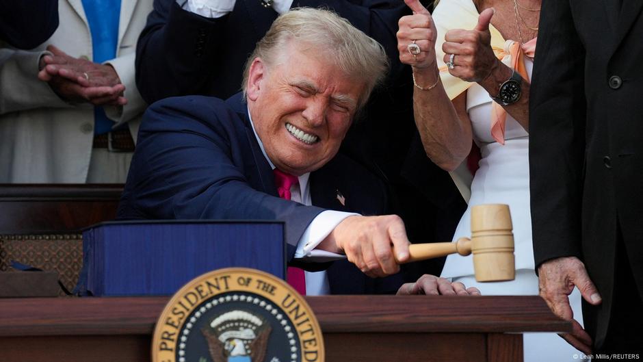 Person in blue suit using wooden gavel at official podium with presidential seal