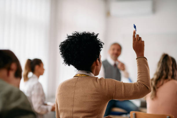 Person raising hand during meeting or conference in professional setting
