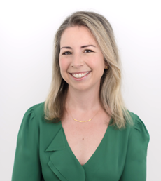 Professional woman in green blouse smiling against neutral background