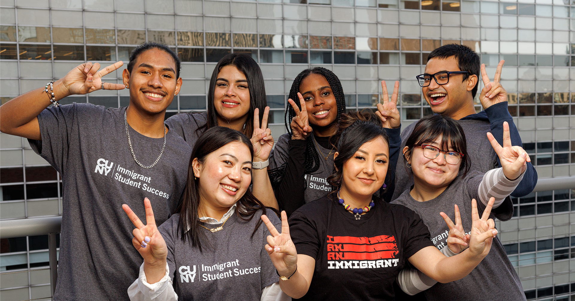 Diverse group of students in Immigrant Student Success shirts posing together