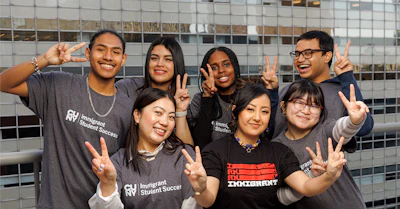Diverse group of students in Immigrant Student Success shirts posing together
