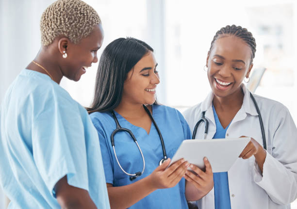 Three healthcare professionals reviewing medical information together, smiling
