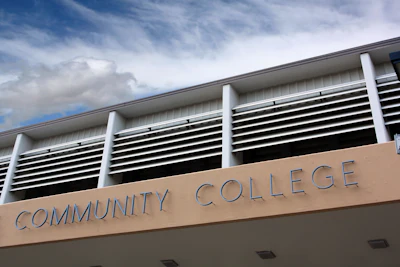 Modern community college building exterior with white columns and blue sky