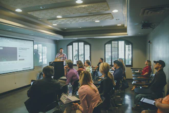 Professional speaker presenting at conference podium to seated audience in modern meeting room with projection screen