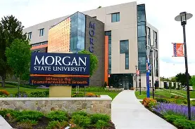 Morgan State University exterior sign on modern building with blue glass panels and purple flowers