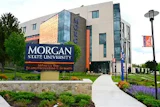 Morgan State University exterior sign on modern building with blue glass panels and purple flowers