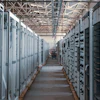 Industrial electrical substation with rows of white and black control cabinets and distribution panels in a warehouse facility